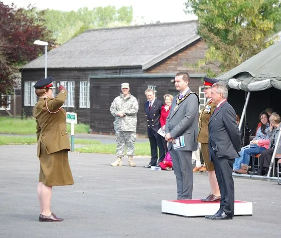 An officer salutes the guests on the dais