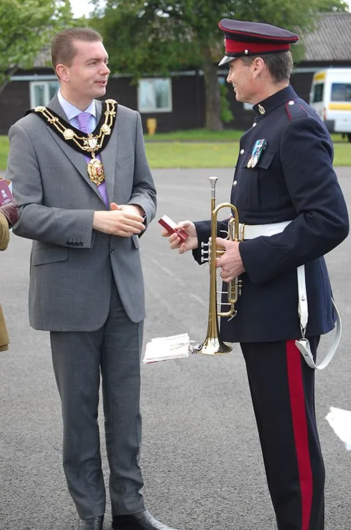 A guest wearing a chain of office talks with a member of the band