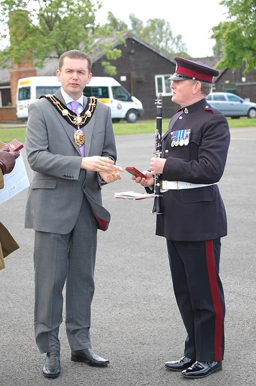 A guest wearing a chain of office with a clarinettist from the band
