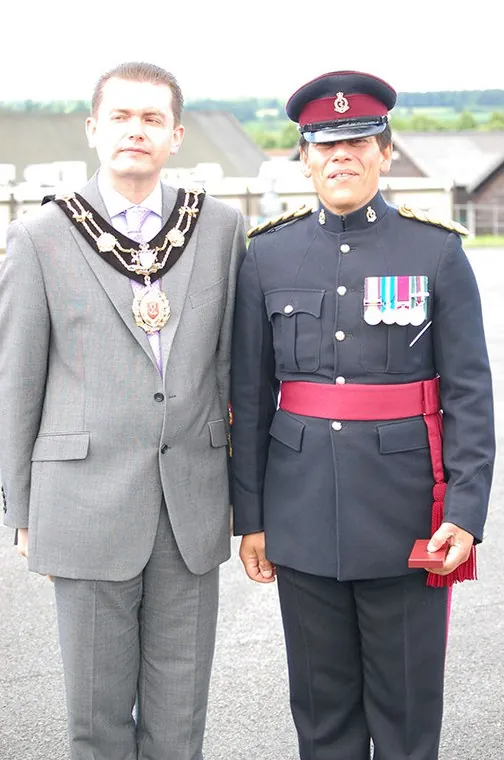 A guest wearing a chain of office beside a member of the band