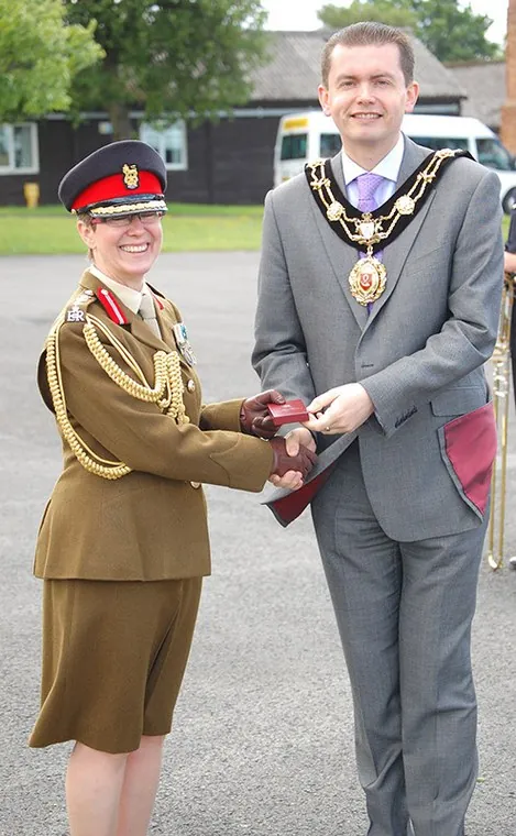 An officer and the guest wearing a chain of office